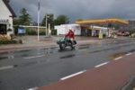 Cadzand in de regen Ernie is ooit, als dertienjarige naar Cadzand Bad gefietst. We besluiten de rit op de motor over te doen. In dertig jaar is Nederland erg veranderd. En vier ouwe motorfietsen zijn wat anders dan een fiets. Zeker als er een zijspan mee rijdt. De rit volgt zo natuurgetrouw de authentieke route. We rijden over fietspaden, door inmiddels gegroeide woonwijken, plantsoenen en winkelcentra. Het is hartje zomer dus iedereen denkt dat we een lokale vakantieactiviteit zijn. Het veer Kruiningen-Perkpolder is niet meer. Maar zo’n tunnel heeft ook wel wat. De oudgedienden daveren door de kilometerslange pijp die zich van voor tot achter met geblaf, geknal en gegrom vult. Wat spelen met de voorontsteking levert een onweersbui van daverende knallen en blauw paarse uitlaatvlammen op. Vakantiegangers het caravans dwarrelen verdoofd in ons spoor. De geluidsorkaan loopt ook voor ons uit. Dat heeft blijkbaar iets te maken met resonantiefrequenties. Het oplopen van blijvende gehoorschade is een feest! Aan de andere kant van de tunnel komen we in een wat sombere klimaatzone, maar we halen Cadzand Bad, de badplaats met de lelijkste boulevard ooit. Het is een lange dag geweest en er moet dus eerst gefoerageerd worden. We lopen naar de Zeemeeuw. Daar is het gezellig druk op het terras. Iedereen knipoogt tevreden naar de zee. De bewolking neemt toe. Jacks en helmen mogen in een hoek van het terras uitrusten. We doen een bier en regelen asbakken. Er zit een man met Harley tattoos op zijn anabole schouders. Hij heeft een aanzienlijk jongere dame bij zich en is erg druk met het negeren van motorrijders zonder Harley tattoos. Zou dat eigenlijk pijn doen, een tattoo zetten? Er vallen wat druppels. Wij bestellen nog wat bier en een driedubbele bittergarnituur. Gefrituurde dingen zijn goed. Want een motor kan ook niet zonder olie. Het begint serieus te regenen. Het terrasvolk vlucht massaal naar binnen. Zomerregen is niet erg. We doen gewoon onze motorspullen weer aan. En waarom zou je je helm niet opzetten omdat je toevallig op een terras zit? De bediening snapt het volkomen. Onze bitterballen en dingen worden opgediend onder plastic. In de eetwaar zijn vrolijke parapluutjes gestoken die doorgaans op sorbets gezet worden. Het is stevig doordrinken om de glazen leeg te krijgen. We zoeken ons honk op. De volgende dag is het weer zomer. In Philippine zit een mosselrestaurant waarvan we de eigenaar kennen. De man heeft een mooie collectie Vincents achter de zaak staan. Een dag is zo voorbij. Op de terugweg is er alleen nog wat consternatie bij de tolpoort. We zeggen dat we niet hoeven te betalen omdat er aan de andere kant van de tunnel een man met een tas staat die de voorverkoop van de kaartjes regelt. Er gaan direct twee tunnelaars met een dienstwagen op zoek naar de zojuist bedachte ondernemer aan het andere eind van de pijp. De terugreis gaat over gebaande wegen. Als je met tachtig over de snelwegen rijdt creëer je je eigen eiland van verkeersstilte. Zo’n Paasweekend is zo voorbij. Jammer. Een goeie bak Alles gaat stuk. Ook BMW versnellingsbakken. Dan blijkt dat een bakrevisie bij professional en beun perfect geklaard kan worden voor € 400,-. Dat moet dus anders kunnen. De lokale dumpmotorhandelaar haalt tegenwoordig BMW R 65 GSsen uit Denemarken. Daar zit vaak wat ongeregeld bij. Hij heeft vijf bakken met kickstarter liggen. Als ik ze allemaal voor hem probeer mag ik een goed exemplaar houden. Alle vijf de bakken blijken rot, maar ik kan nu wel bakken wisselen binnen een uur. Internetjagerij leert dat bakken voor een euro of driehonderd worden aangeboden. Dan komt Waldemar in beeld. Waldemar is van de digitalegeneratie en hij is slim geboren. Hij gaat zoeken onder ‘R45’. Dat is het soort boxer dat in alle asiels preventief wordt geruimd omdat er toch geen baasje voor te vinden is. Ergens in Noord Holland biedt iemand R45 spullen aan. In de advertentie staat een kompleet gedemonteerde R45 minus het kenteken. Daar zit een bak bij en die moet €199,- kosten. Het frame kost 199,- euro. De tank en zijdeksels 199,- euro. Alles voor 199,- euro per portie. Een R45 bak kan nooit veel geleden hebben. Want R45’s zitten boordevol geen vermogen. En Den Helder… Daar was ik in geen twintig jaar geweest. Om overtuigend over te komen pakten kameraad Ernie en ik de BX van mijn Lief. BX rijders staan op Wiki Pedia als schoolvoorbeelden voor scharrige lieden zonder geld. Den Helder ligt verder weg dan de meeste mensen denken. Maar uiteindelijk reden we een Vinex achtig wijkje in waar zelfs geen Prozac tegen gewassen was. Het opgegeven huisnummer straalde de troosteloze somberheid in overtreffende trap uit. In de gang rook het naar toiletverfrisser die de strijd had verloren en doorgekookte andijvie. Nu zagen we wat R45 rijden te weeg kon brengen. We kregen tekst en uitleg. De motoren waren erfstukken. De erfgenaam was professioneel uitkeringsgerechtigd. Hij had de kentekens en kentekenplaten ingeleverd en de motoren zo hun bestaan ontnomen. Zo kon de verkoop buiten de boeken gehouden worden. Slim. Een vriend had hem aangeraden op Marktplaats te adverteren. Ook slim. Bovendien had vriendmans gezegd alles aan te bieden voor € 199,- per te verkopen eenheid. Want dat scheelde weer € 6,- advertentiekosten. Ook heel slim. Met zulke vrienden heb je geen vijanden nodig. Het was even passen en meten om de spullen achter in de BX te krijgen. Maar de twee motorblokken, de twee versnellingsbakken, de twee tank/zit/zijdekselsets en de twee frames met vorken pasten er in. We sloegen de aangeboden koffie af en vluchten weer naar het oosten. De R 45 bak werd gemonteerd en schakelde tevreden klikklakkend als nieuw. Prima geregeld.