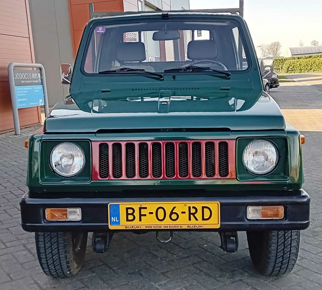 Vooraanzicht van een groene Suzuki SJ 410 pickup met rode grille