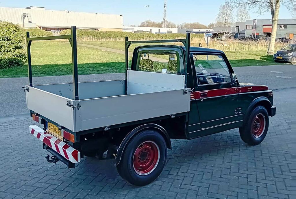 Suzuki SJ 410 pickup in bedrijfskleuren, gezien van achter drie-kwart