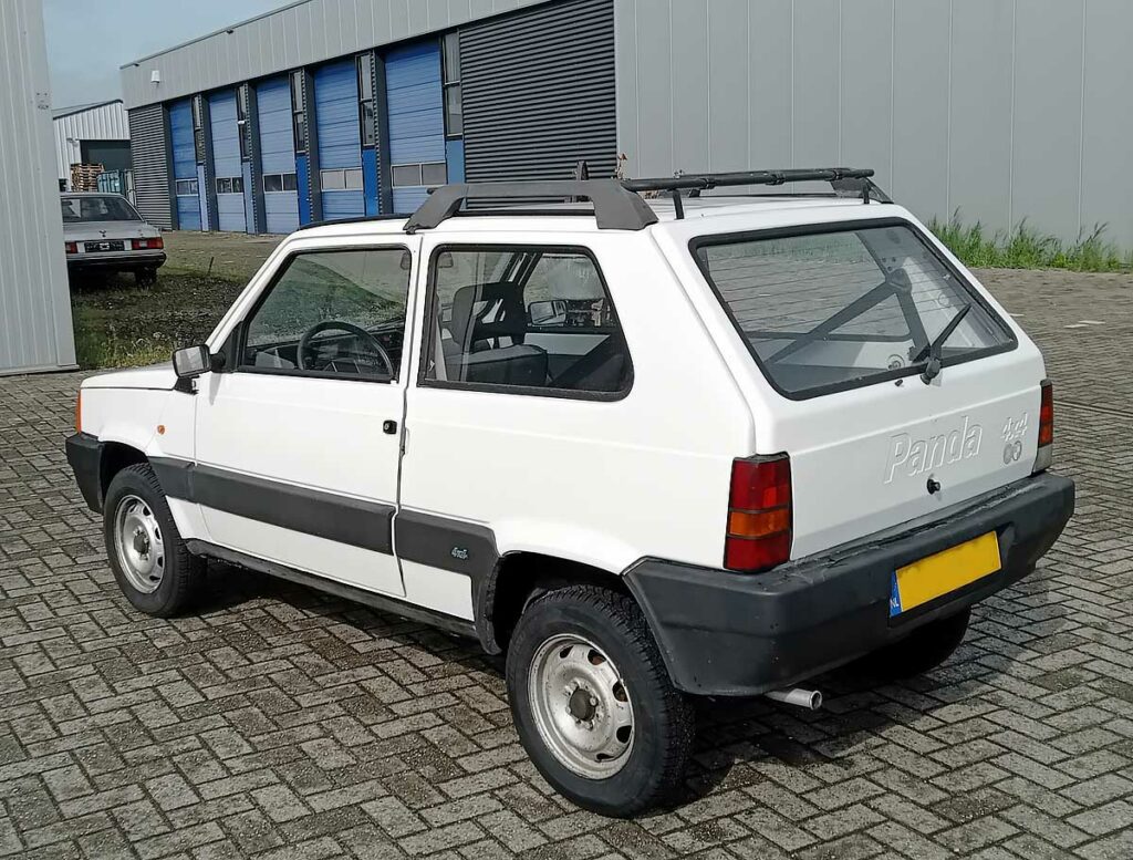 Witte FIAT Panda 4x4 uit 1998, achterzijde links, met dakdragers op industrieterrein