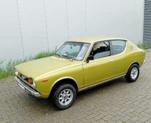 Goudkleurige Datsun 100A uit 1975 in voor drie-kwart linker aanzicht
