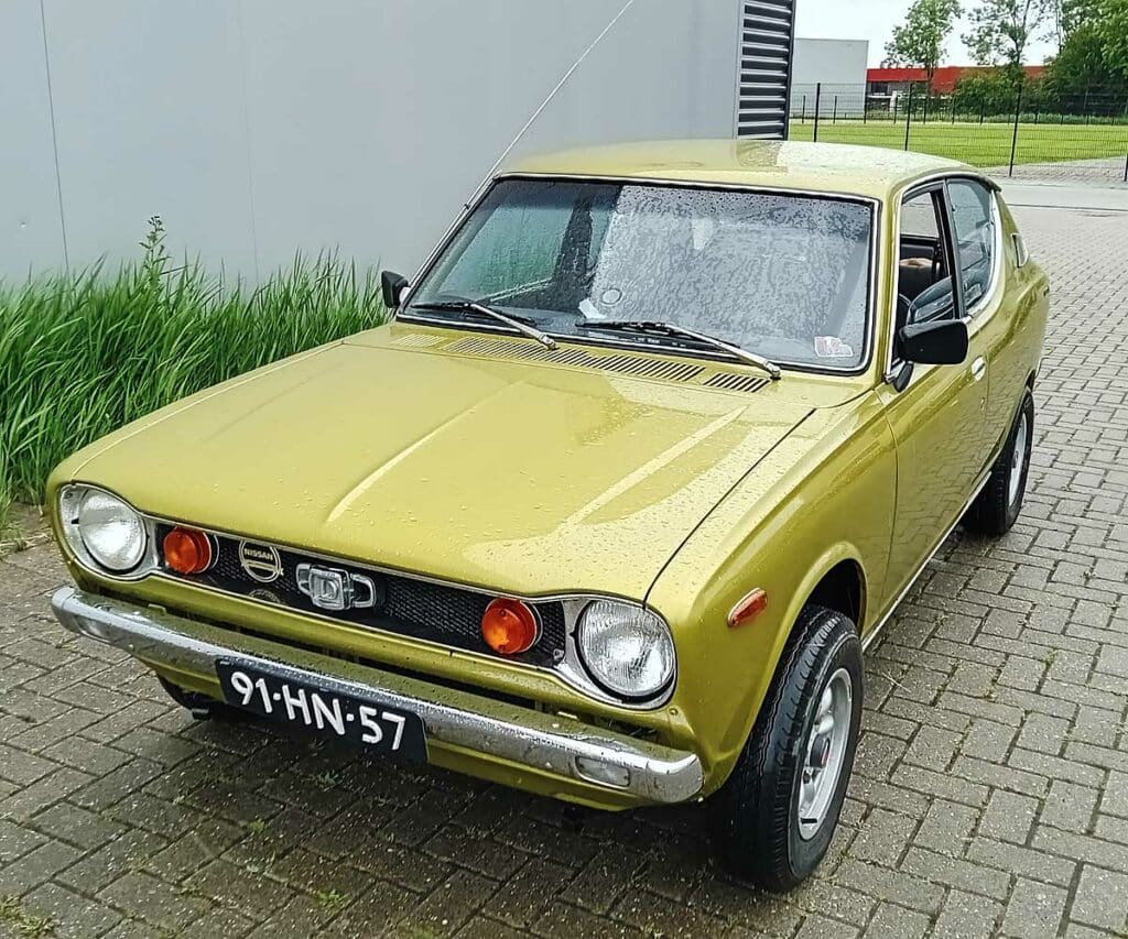 Voorzijde van een Datsun 100A uit 1975 met ronde koplampen en originele grille